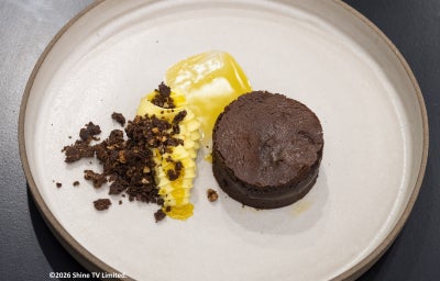 Foto da Receita de Gâteau de Chocolate com Tangerina e Crumble vista de cima, servida em um prato de cor bege